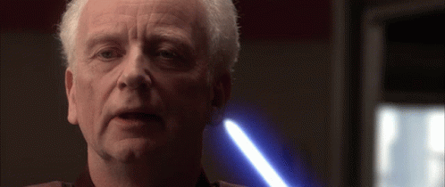 A Close Up Of A Man 'S Face With A Blue Light In The Background GIF