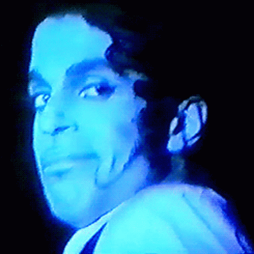A Close Up Of A Man 'S Face With A Blue Light Shining On It GIF