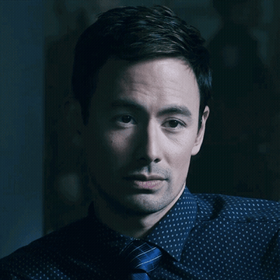 A Close Up Of A Man 'S Face With A Blue Shirt And Tie GIF