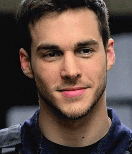 A Close Up Of A Man 'S Face With A Blue Shirt On GIF