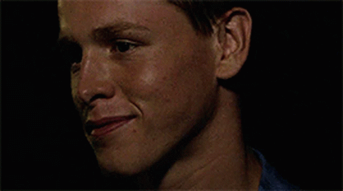 A Close Up Of A Man 'S Face With A Blue Shirt On GIF