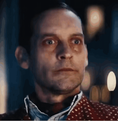 A Close Up Of A Man 'S Face With A Blurred Background And A Polka Dot Shirt . GIF