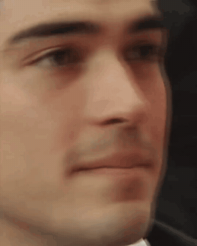 A Close Up Of A Man 'S Face With A Blurred Background Making A Funny Face . GIF
