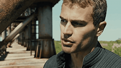 A Close Up Of A Man 'S Face With A Bridge Behind Him GIF