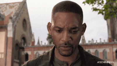 A Close Up Of A Man 'S Face With A Building In The Background GIF