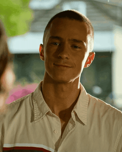 A Close Up Of A Man 'S Face With A Button Down Shirt GIF