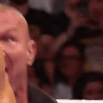 A Close Up Of A Man 'S Face With A Crowd Behind Him . GIF