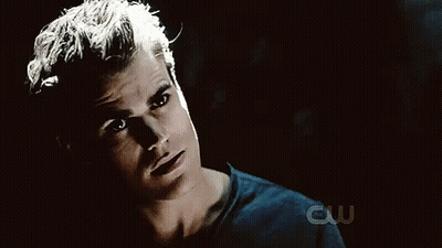 A Close Up Of A Man 'S Face With A Cw Logo Behind Him GIF