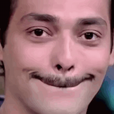 A Close Up Of A Man 'S Face With A Fake Mustache Making A Funny Face . GIF