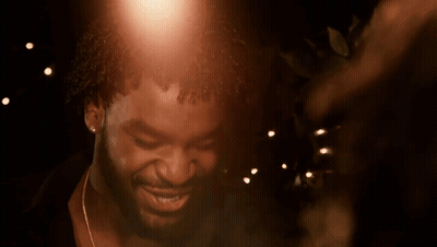 A Close Up Of A Man 'S Face With A Few Lights In The Background GIF