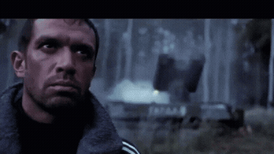 A Close Up Of A Man 'S Face With A Fire Behind Him GIF