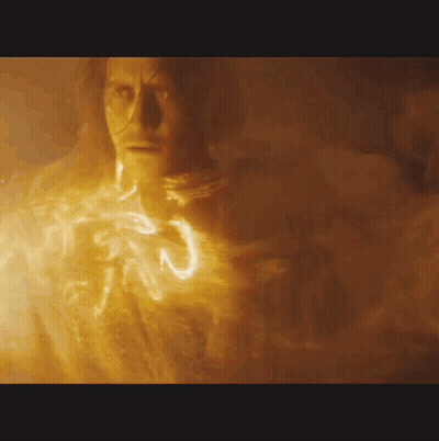 A Close Up Of A Man 'S Face With A Glowing Light Coming Out Of His Chest . GIF