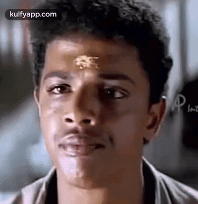 A Close Up Of A Man 'S Face With A Gold Sticker On His Forehead . GIF