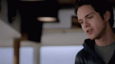 A Close Up Of A Man 'S Face With A Gray Shirt And A Black Jacket GIF
