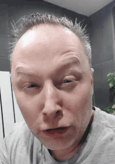 A Close Up Of A Man 'S Face With A Gray Shirt GIF