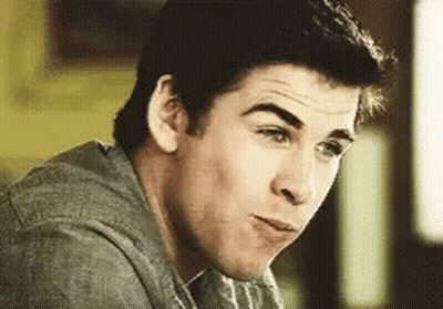 A Close Up Of A Man 'S Face With A Gray Shirt On Making A Funny Face . GIF