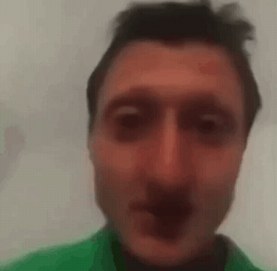 A Close Up Of A Man 'S Face With A Green Shirt On . GIF