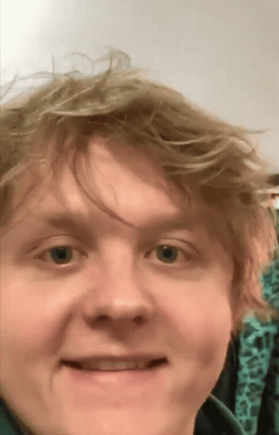 A Close Up Of A Man 'S Face With A Green Shirt On GIF