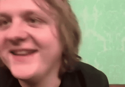 A Close Up Of A Man 'S Face With A Green Wall In The Background . GIF
