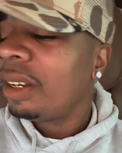 A Close Up Of A Man 'S Face With A Hat And Earrings GIF