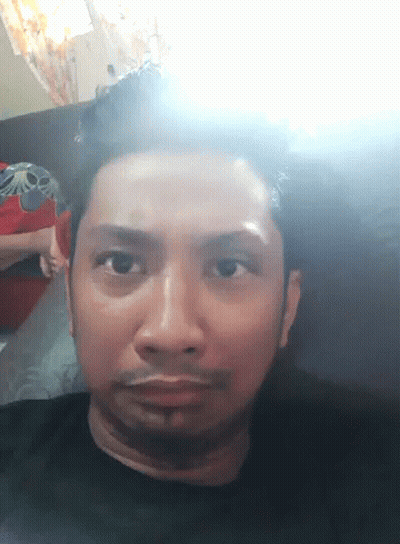 A Close Up Of A Man 'S Face With A Light Shining On It GIF