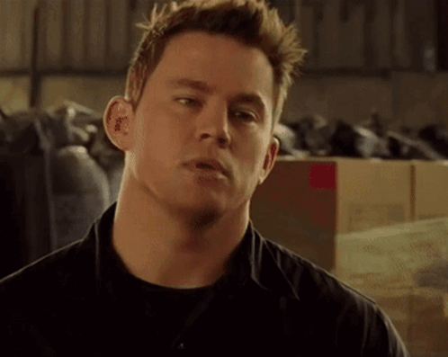 A Close Up Of A Man 'S Face With A Lot Of Boxes In The Background GIF