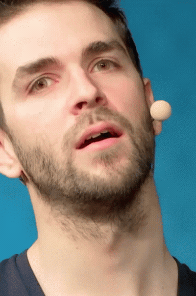 A Close Up Of A Man 'S Face With A Microphone Behind His Ear GIF