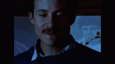 A Close Up Of A Man 'S Face With A Mustache And A Blue Shirt GIF