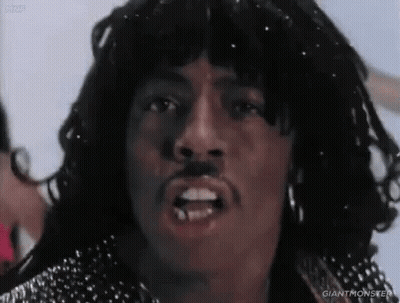 A Close Up Of A Man 'S Face With A Mustache And Earrings . GIF