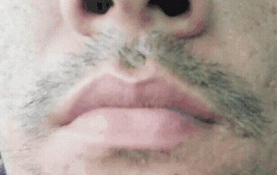 A Close Up Of A Man 'S Face With A Mustache And Lips . GIF