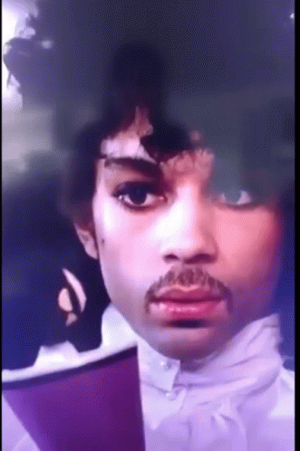 A Close Up Of A Man 'S Face With A Mustache And Purple Hair GIF
