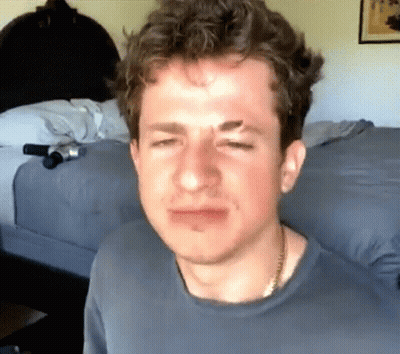 A Close Up Of A Man 'S Face With A Necklace Around His Neck GIF