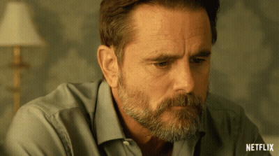 A Close Up Of A Man 'S Face With A Netflix Logo Behind Him GIF