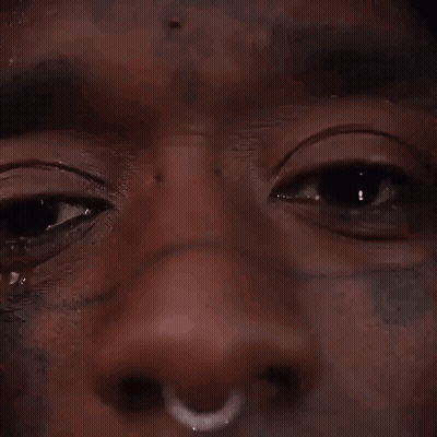 A Close Up Of A Man 'S Face With A Nose Ring And A Tear Running Down His Face . GIF