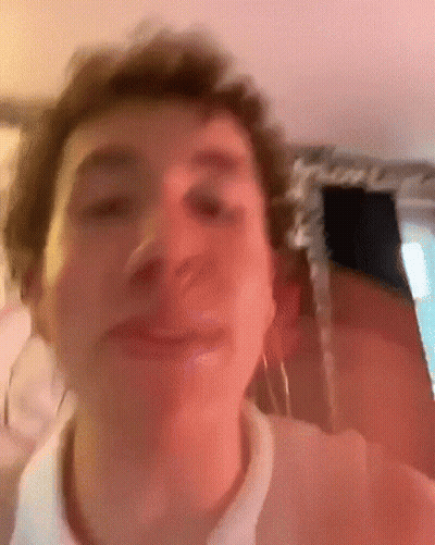 A Close Up Of A Man 'S Face With A Pink Background . GIF