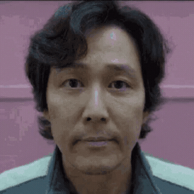 A Close Up Of A Man 'S Face With A Pink Background And A Beard . GIF