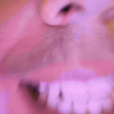 A Close Up Of A Man 'S Face With A Pink Background GIF