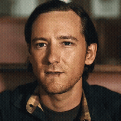 A Close Up Of A Man 'S Face With A Plaid Shirt On GIF
