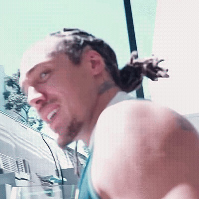A Close Up Of A Man 'S Face With A Ponytail GIF
