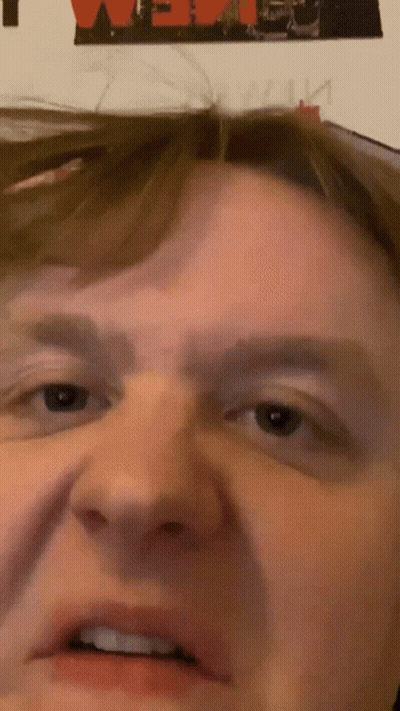 A Close Up Of A Man 'S Face With A Poster In The Background That Says ' We ' GIF