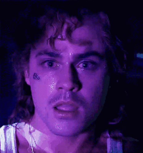 A Close Up Of A Man 'S Face With A Purple Background . GIF