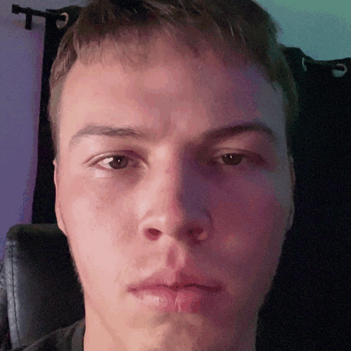 A Close Up Of A Man 'S Face With A Purple Curtain In The Background GIF