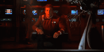 A Close Up Of A Man 'S Face With A Red Light Behind Him GIF