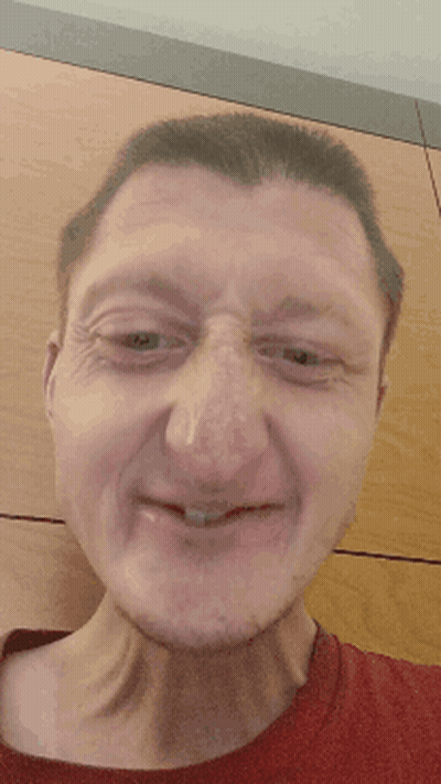A Close Up Of A Man 'S Face With A Red Shirt On GIF