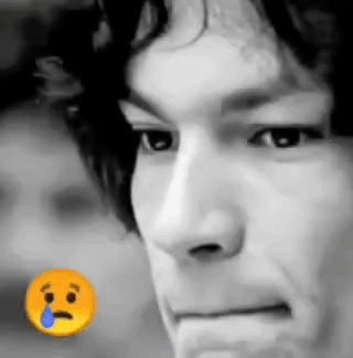 A Close Up Of A Man 'S Face With A Sad Smiley Face Next To It . GIF