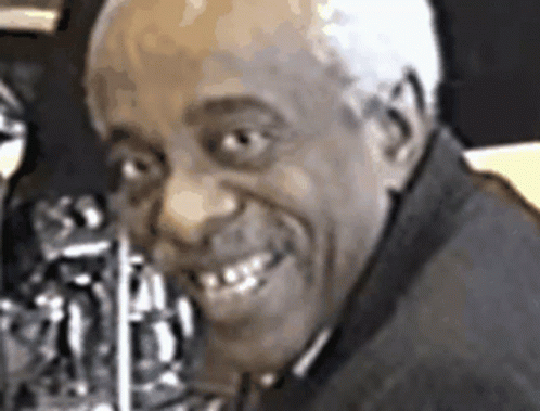 A Close Up Of A Man 'S Face With A Saxophone In His Mouth GIF