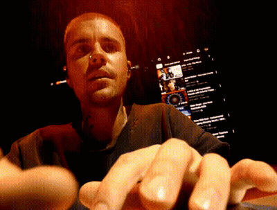 A Close Up Of A Man 'S Face With A Screen Behind Him That Says ' Youtube ' On It GIF