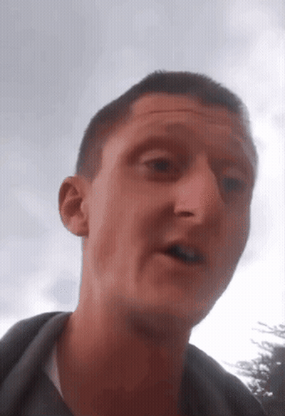 A Close Up Of A Man 'S Face With A Sky Background GIF
