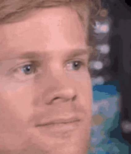 A Close Up Of A Man 'S Face With A Slight Smile On His Face . GIF