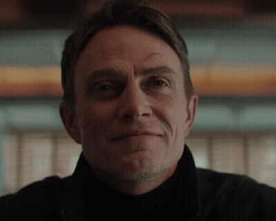 A Close Up Of A Man 'S Face With A Slight Smile On His Face GIF